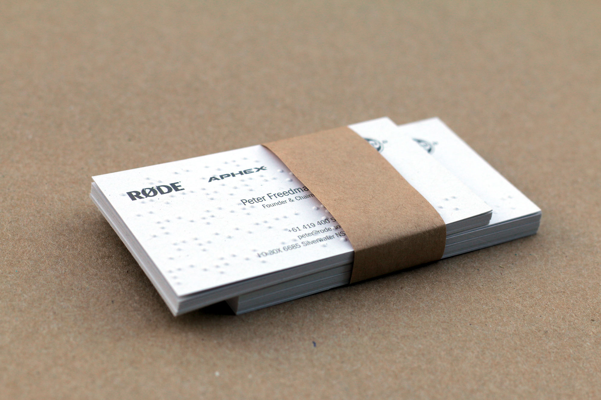 RØDE business cards with raised tactile dots, bundled with a recycled paper band